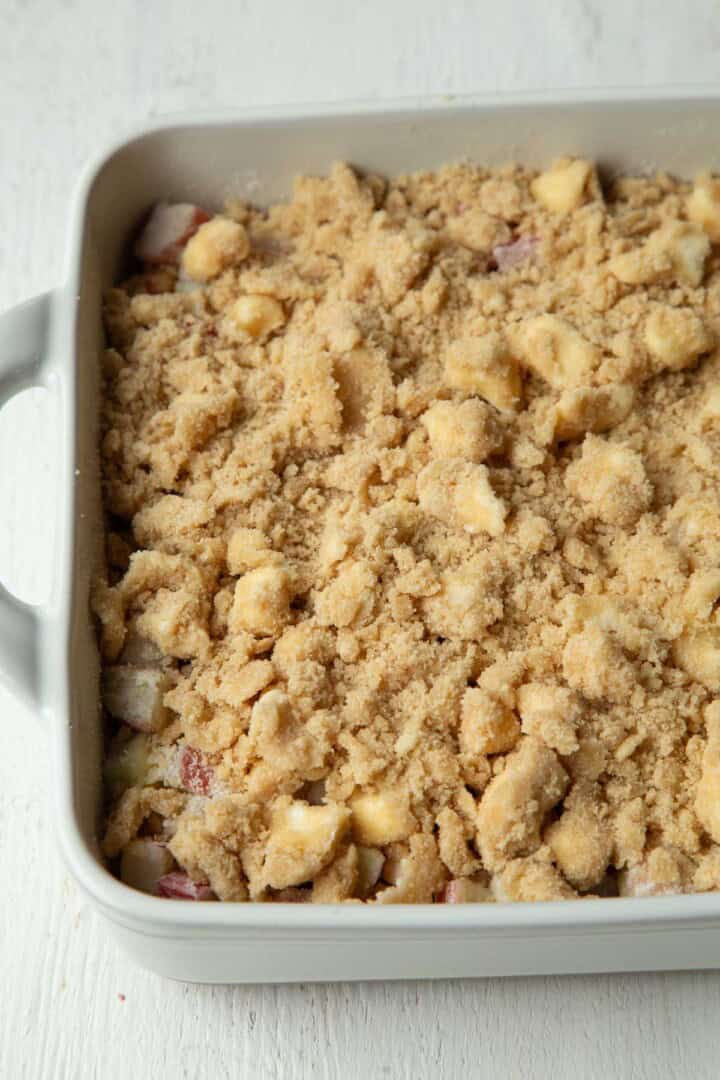 buttery crumble on top of a rhubarb mixture in a baking dish.