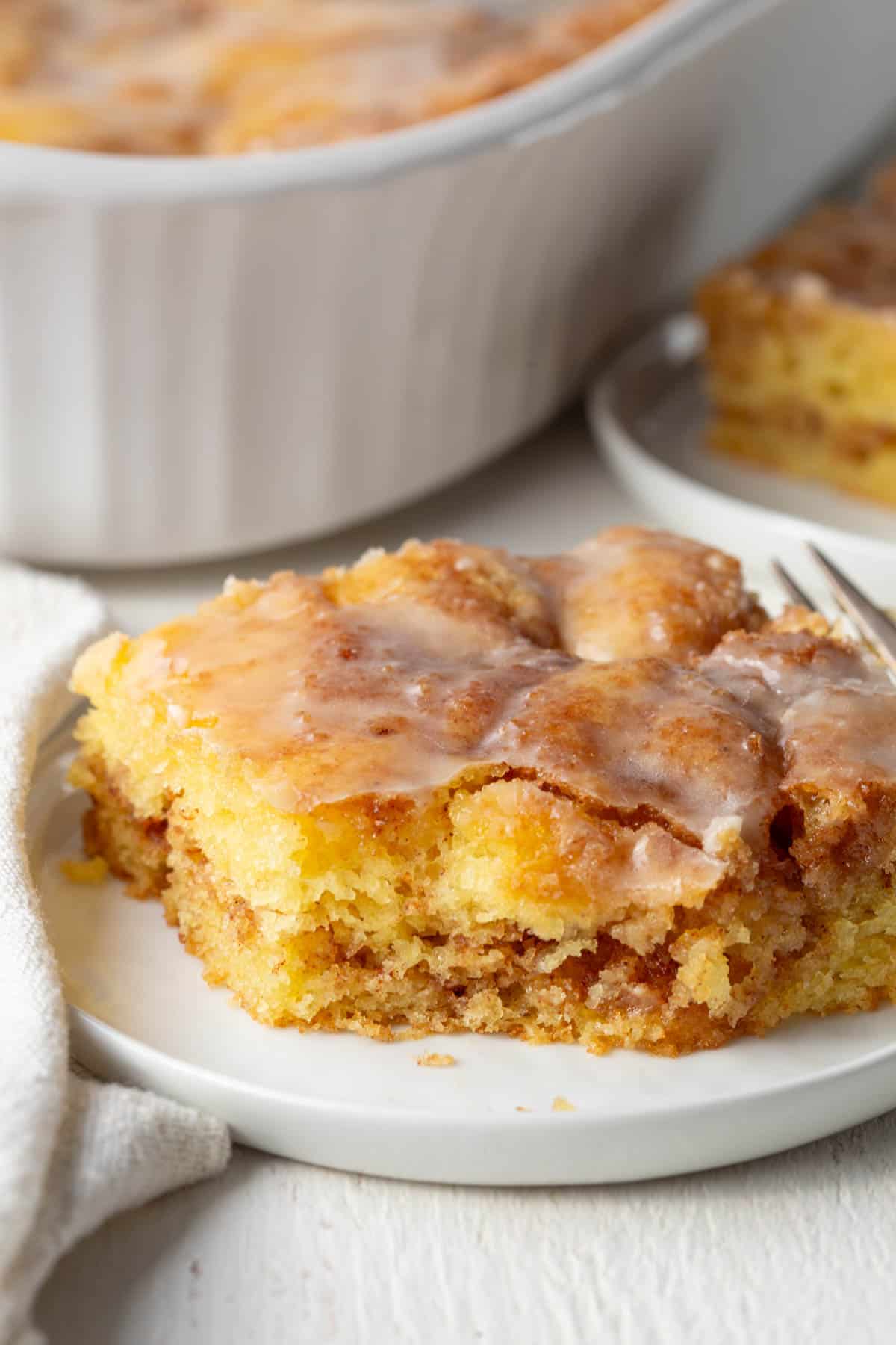 slice of honey bun cake with a bite taken out.