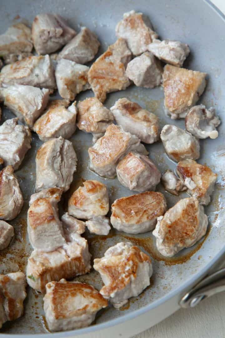 cubes of browned pork tenderloin in a skillet.
