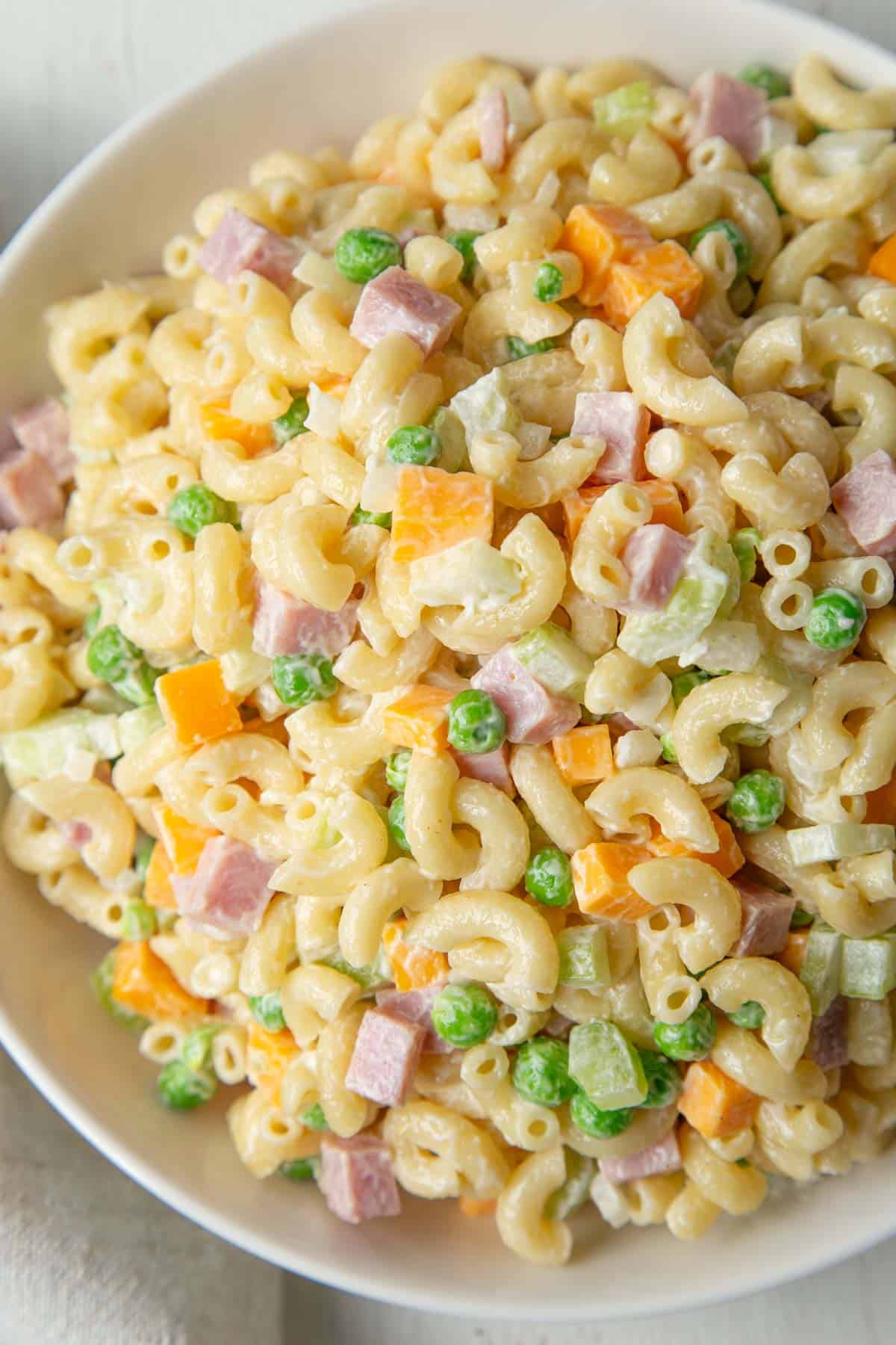 big bowl of creamy macaroni salad with ham, peas, and cheddar.