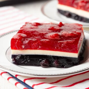 slice of red, white, and blue layered jello dessert on a white plate.