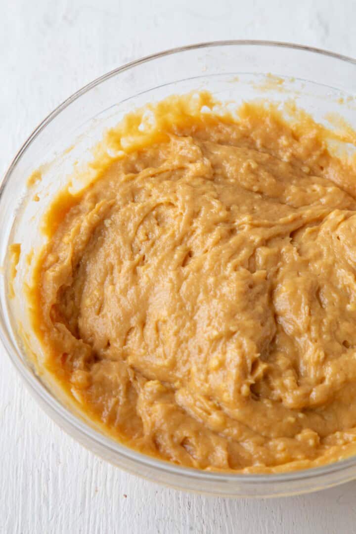 yellow-orange hued cake batter in a glass bowl.