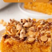 a slice of butterscotch cake with butterscotch chips on top.