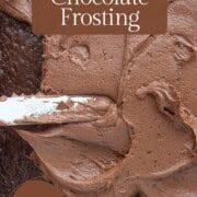 rich chocolate frosting being spread on a chocolate cake.