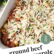 ground beef and zucchini casserole topped with shredded mozzarella cheese in a casserole dish.