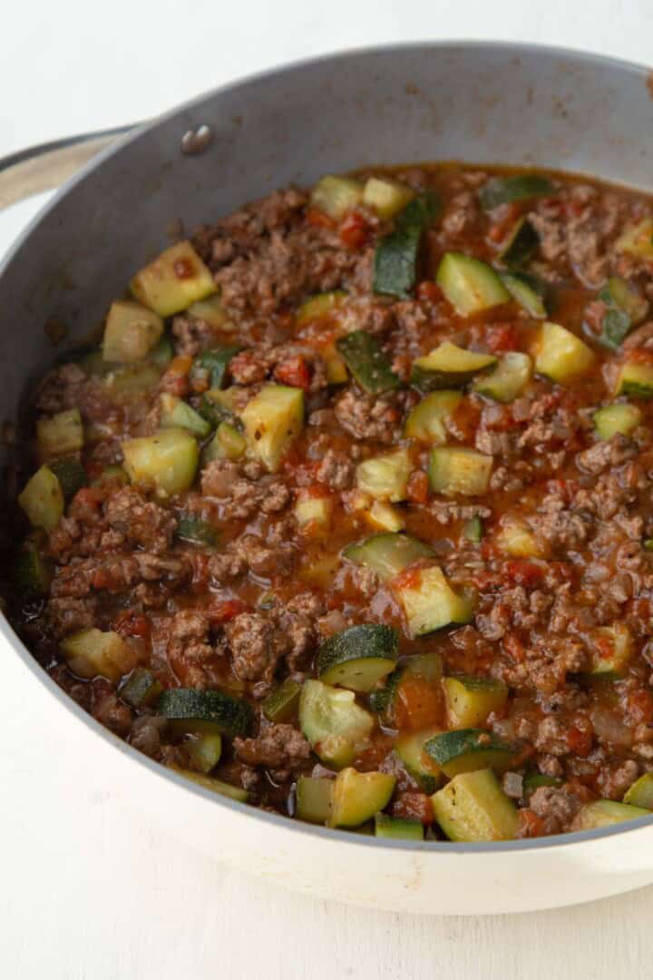 ground beef and zucchini in a tomato mixture in a skillet.