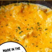 chicken and rice covered with melted cheese in a slow cooker.