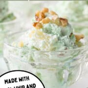 light green hued fluffy whipped topping salad topped with nuts in a parfait dish.