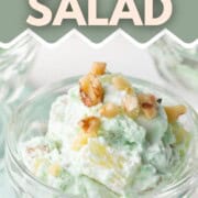parfait dish filled with light green fluffy salad with chopped walnuts on top.