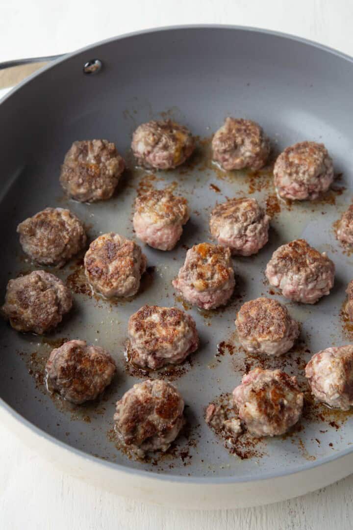 bite-sized meatballs browned in a skillet.