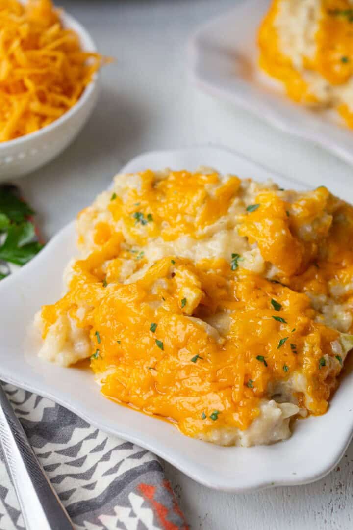 chicken and rice mixture topped with melted cheese on a white plate.