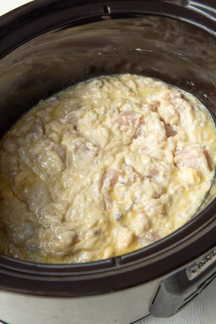 raw chicken and raw rice in cream of mushroom soup in a crockpot.