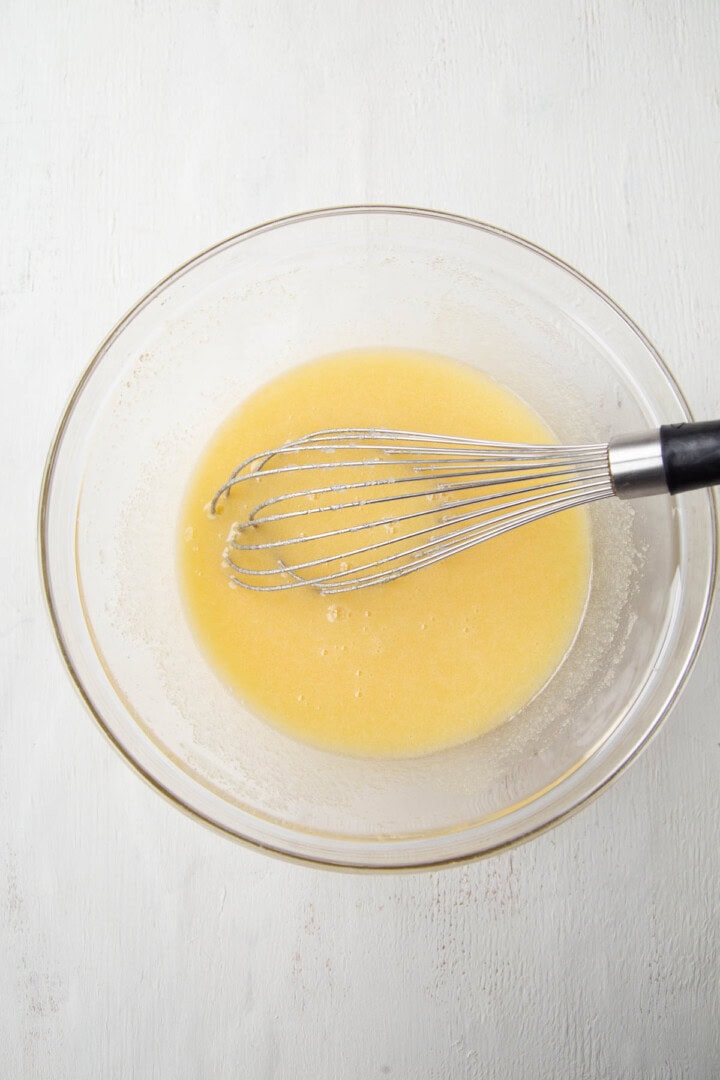 eggs and sugar whisked together in a glass bowl.