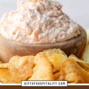 pink shrimp dip in a wooden bowl surrounded by potato chips.