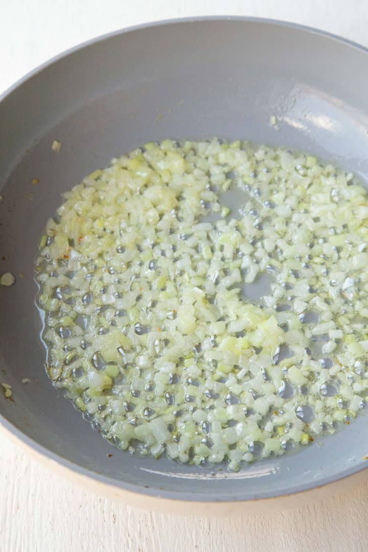 butter and onions cooking in a skillet.