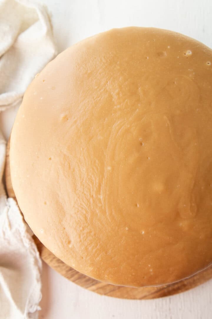 round cake topped with a smooth layer of caramel icing.