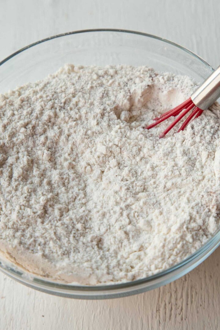 flour and baking soda mixture with a whisk in a glass bowl.
