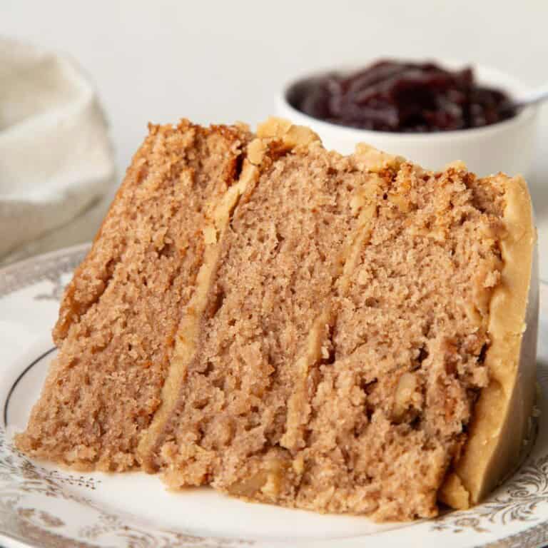 slice of three layer jam cake with caramel icing.