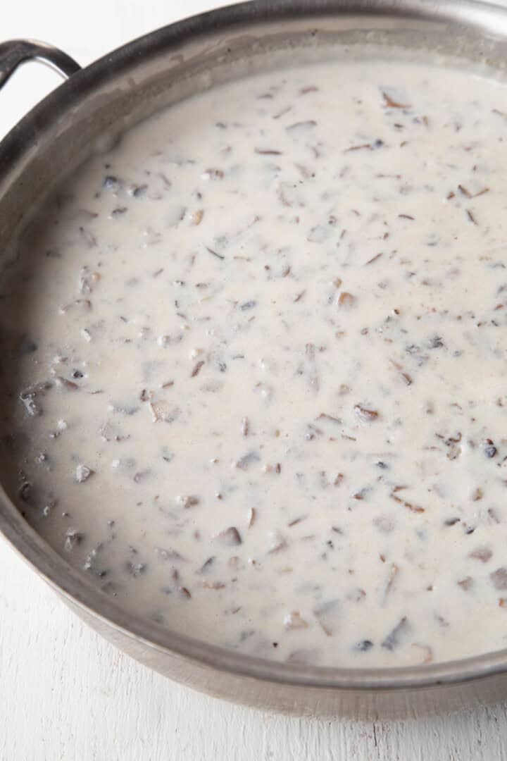 creamy white soup with pieces of chopped mushrooms.
