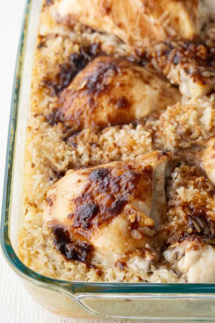 baked chicken on top of a creamy rice mixture.