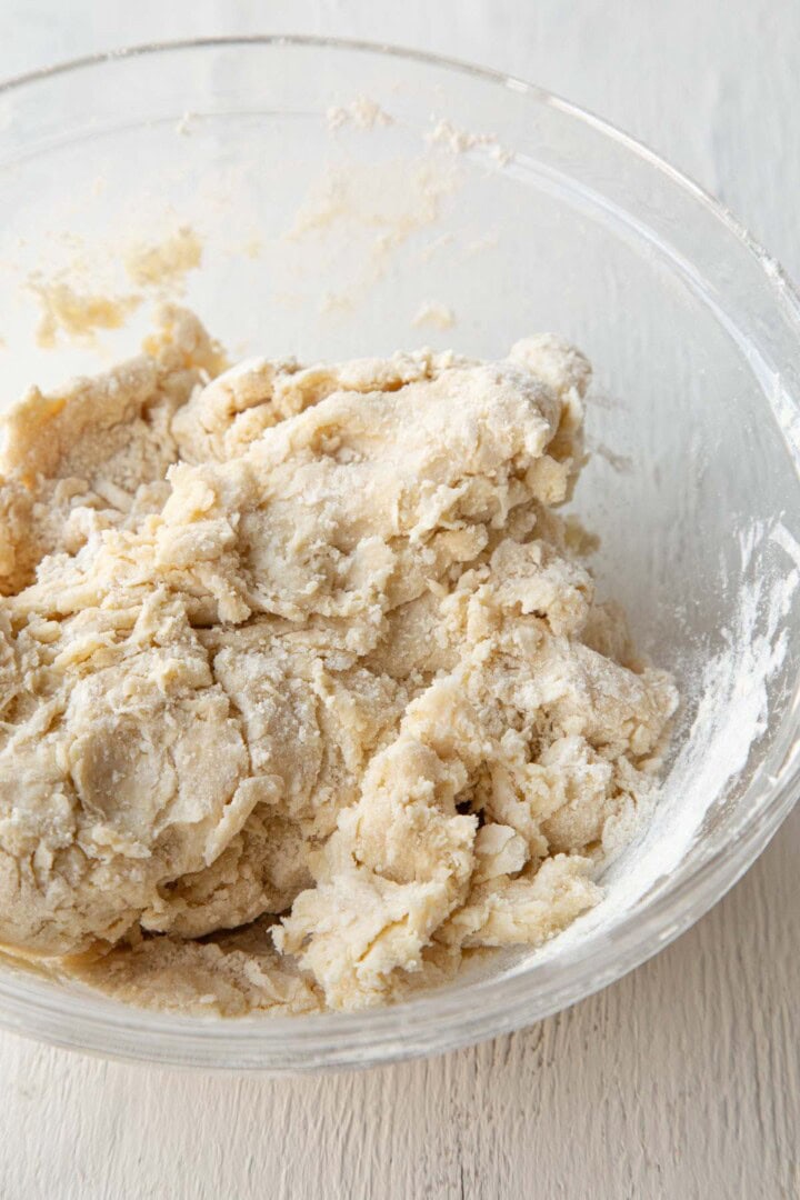 a shaggy pie dough in a glass bowl.