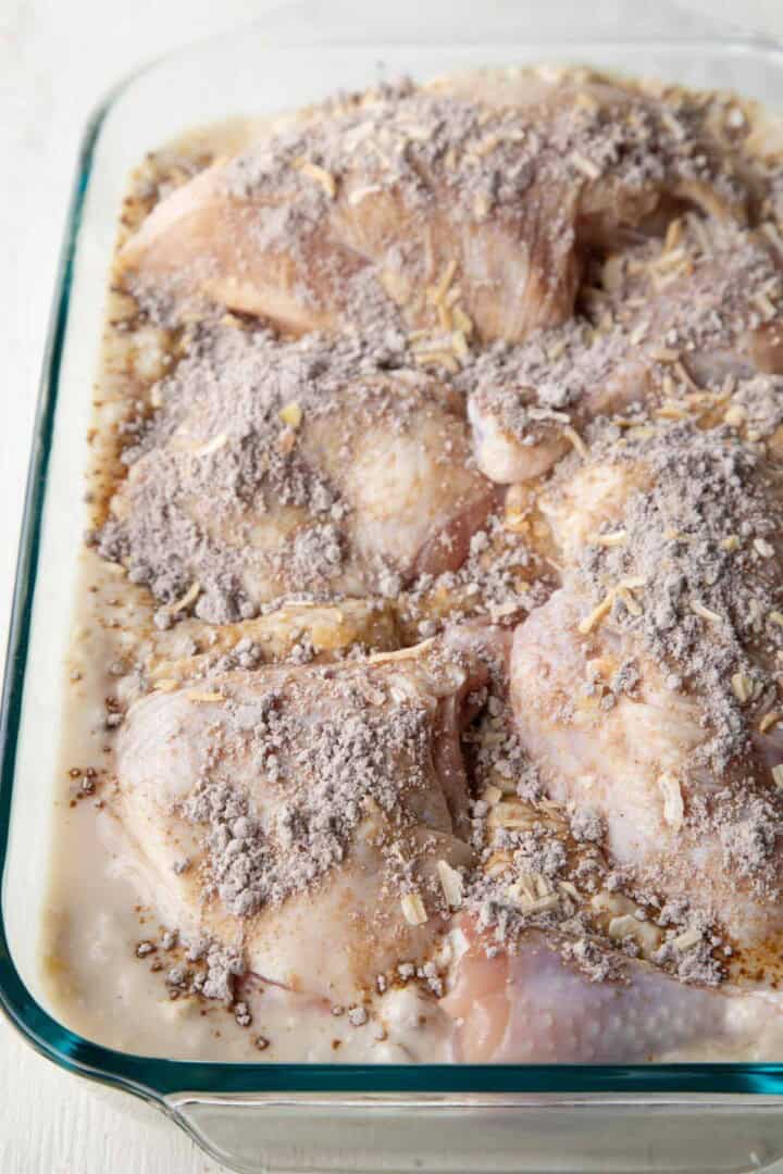 raw chicken on top of a creamy rice mixture, with powdered onion soup mix sprinkled on top.