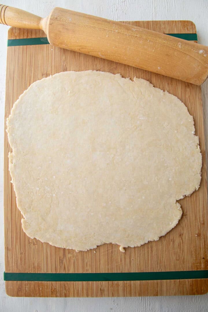 pie dough rolled out on a cutting board.