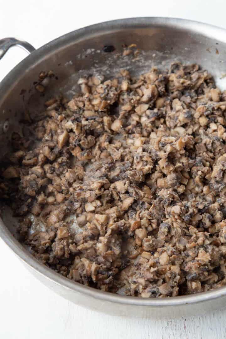 chopped and cooked mushrooms coated in flour in a skillet.