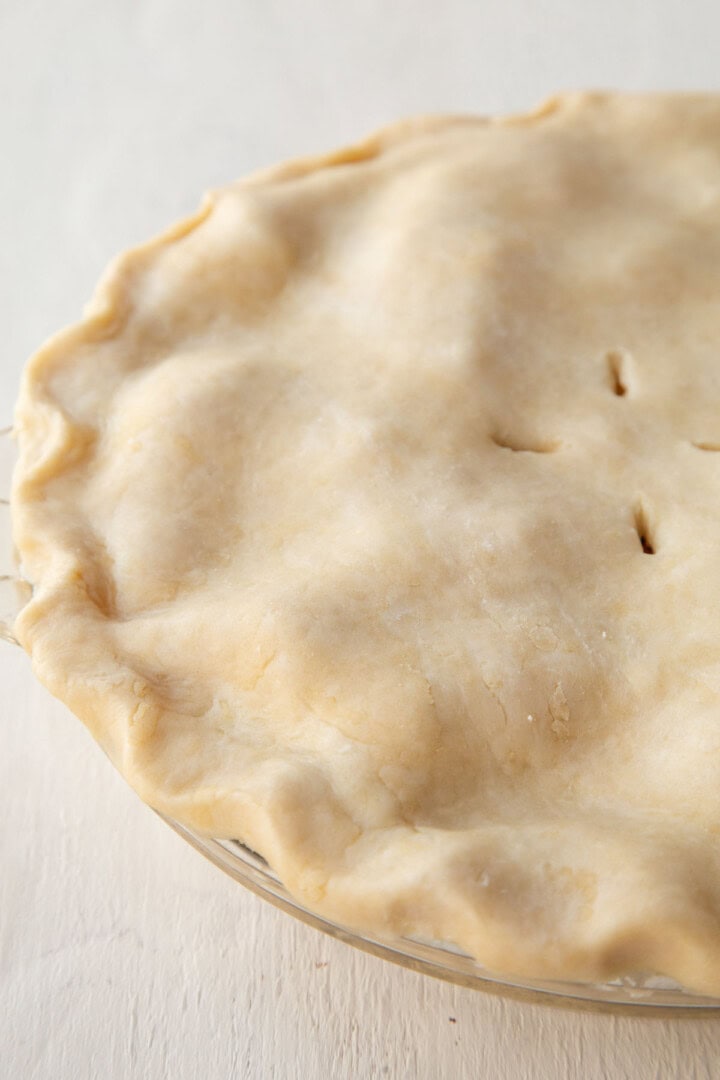 unbaked pie crust on top of a pie with fluted edges.