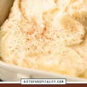 mashed potatoes in a casserole dish topped with paprika.