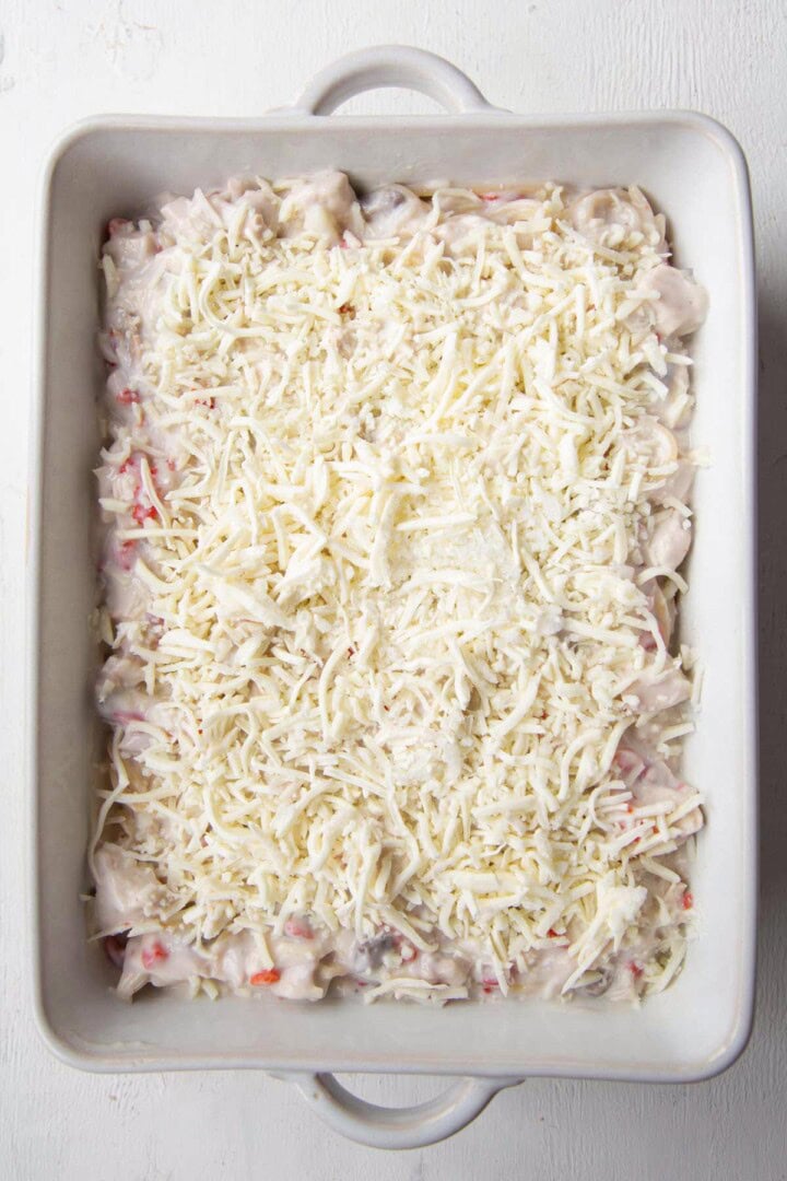 casserole dish filled with creamy pasta and turkey, topped with shredded cheese.