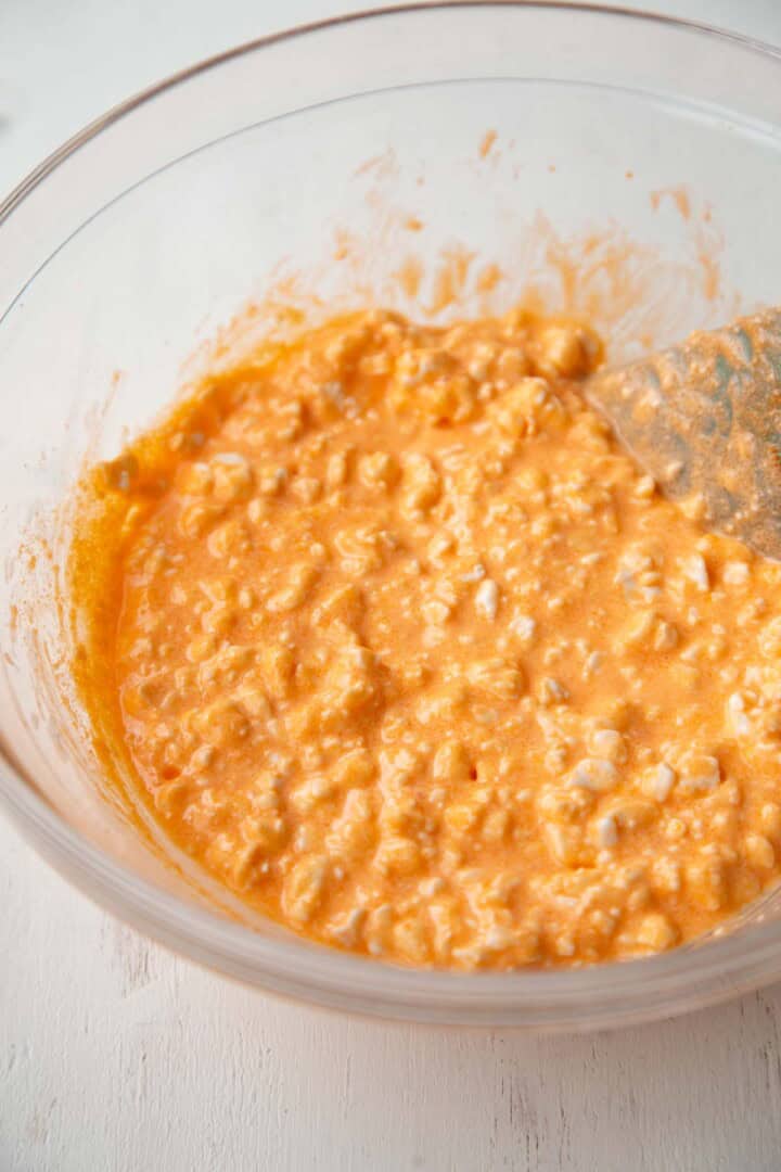 cottage cheese and orange gelatin powder in a bowl.