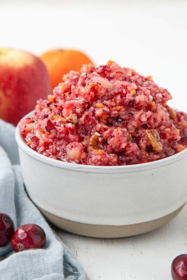 cranberry relish with bits of chopped orange peel in a white dish.