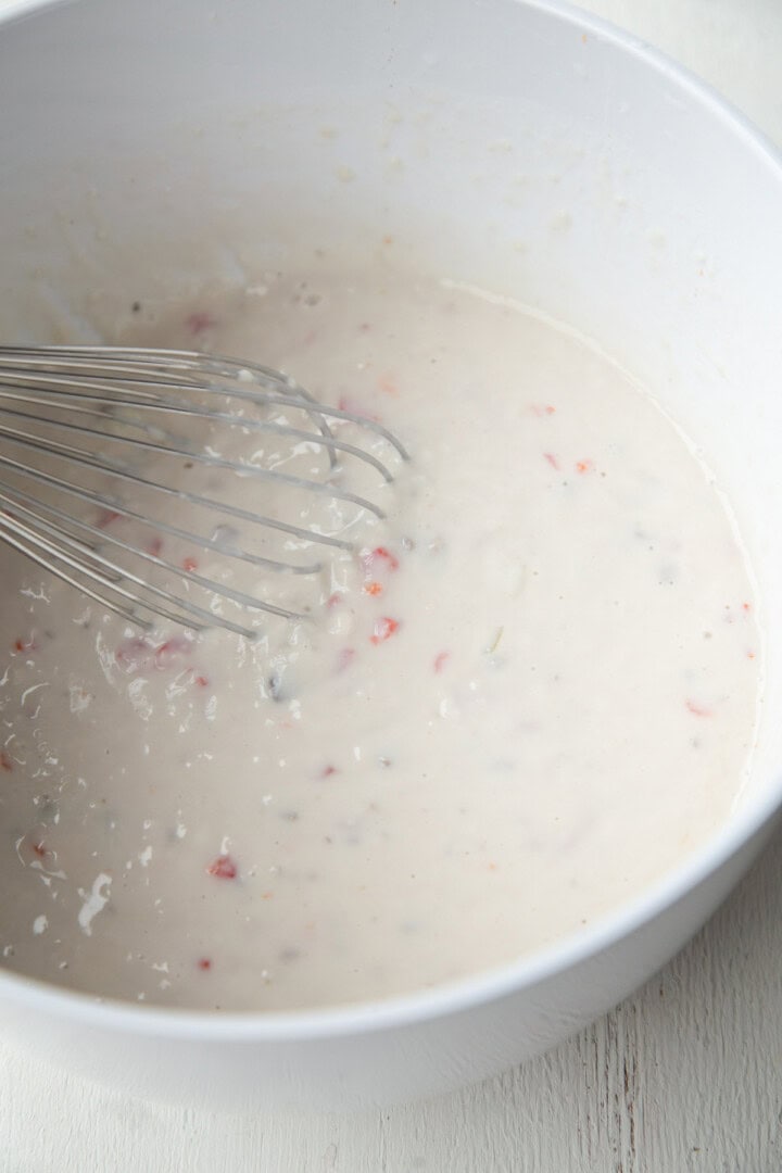 cream of mushroom soup, milk, and pimentos in a large bowl with a whisk.