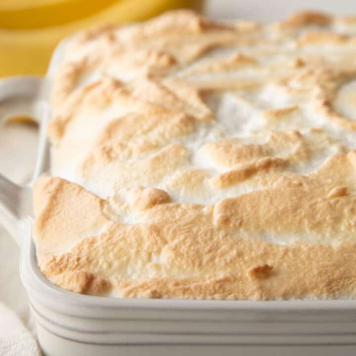 toasted meringue on top of banana pudding in a casserole dish.