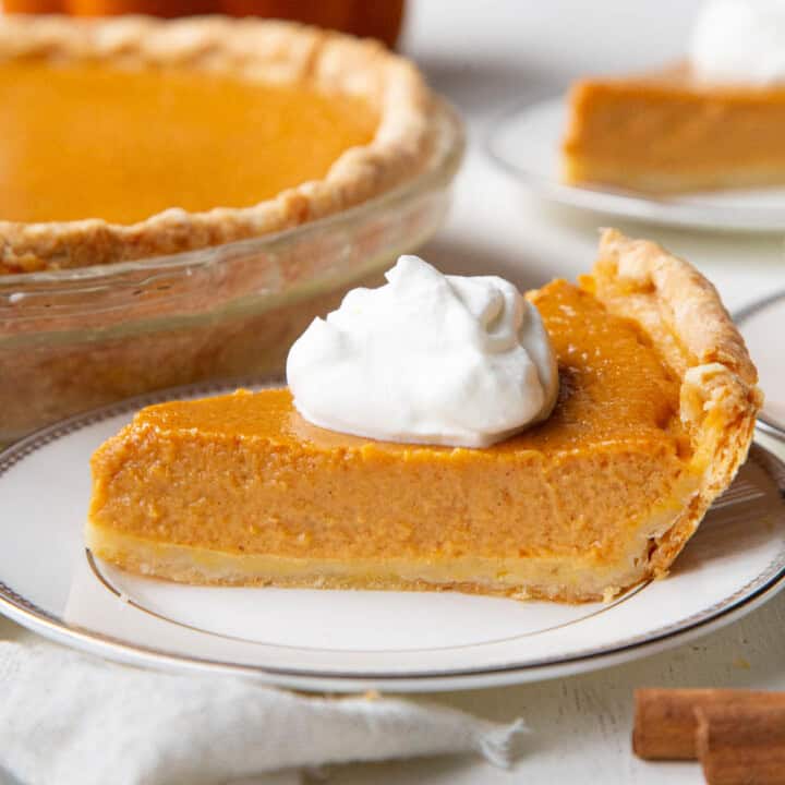 slice of pumpkin pie topped with a dollop of whipped cream.