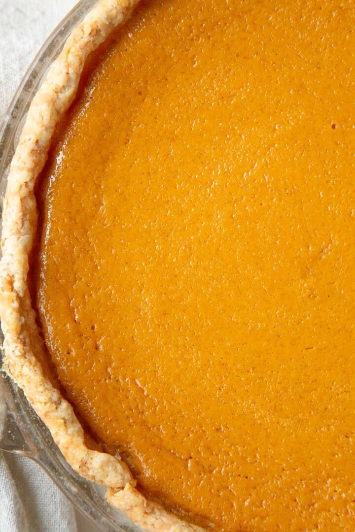 whole pumpkin pie with a rolled pie crust edge.