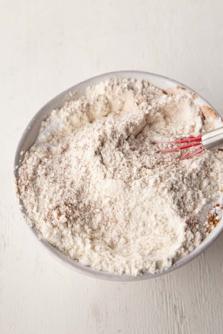 flour mixture with a whisk in a white bowl.