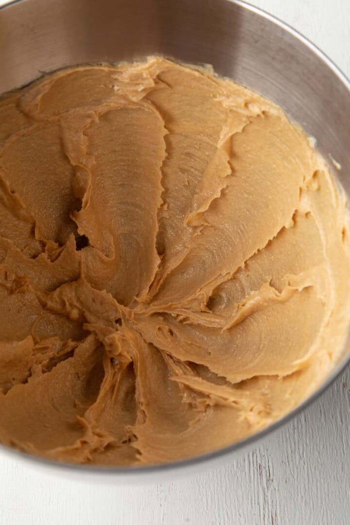 butter, sugar, and peanut butter creamed together in a metal bowl.