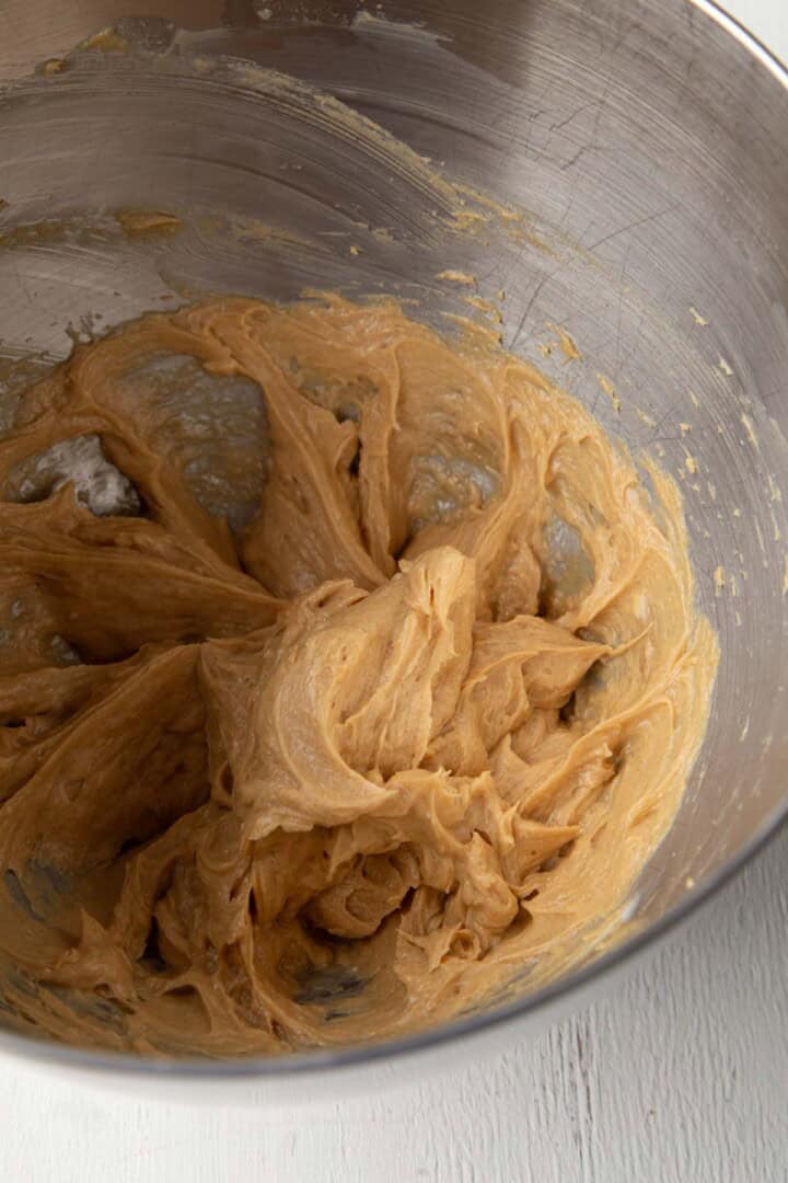 butter, sugar, eggs, and peanut butter creamed in a bowl.