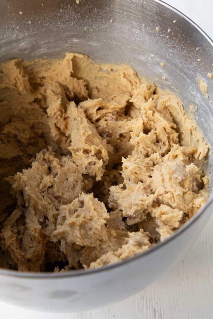 beige colored cookie dough in a metal bowl.