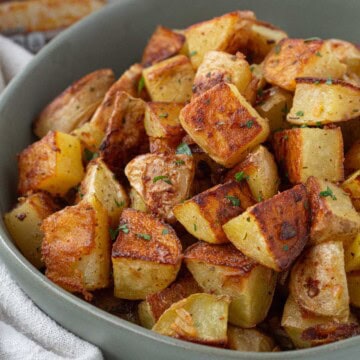 bowl of crispy roasted potatoes with french onion soup mix seasoning coating the outside.