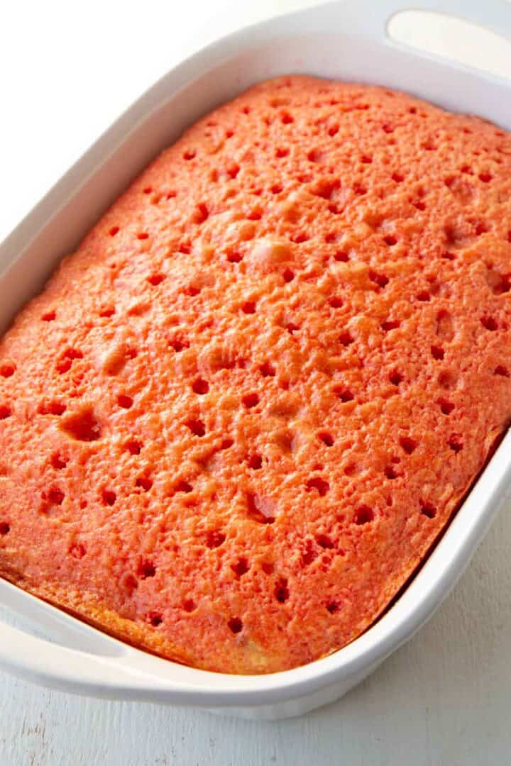 yellow cake with holes in it, topped with strawberry gelatin.