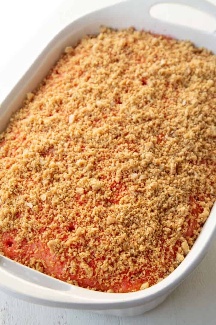 graham cracker crumbs on top of a poke cake.