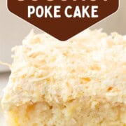 slice of yellow cake with bits of pineapple inside, topped with a fluffy frosting and toasted coconut.