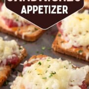 mini reuben sandwiches with a square of toasted rye bread topped with corned beef and melted swiss cheese on a sheet pan.