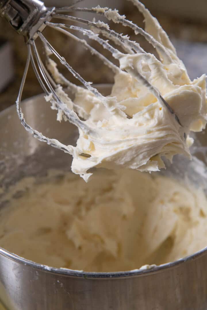 smooth cream cheese frosting on the beater of a stand mixer.