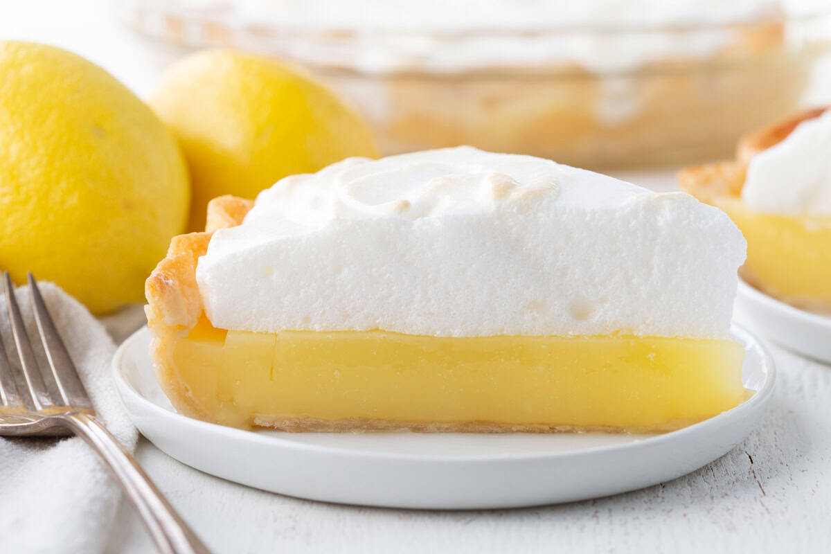 slice of lemon pie with a yellow lemon layer topped with a fluffy meringue.
