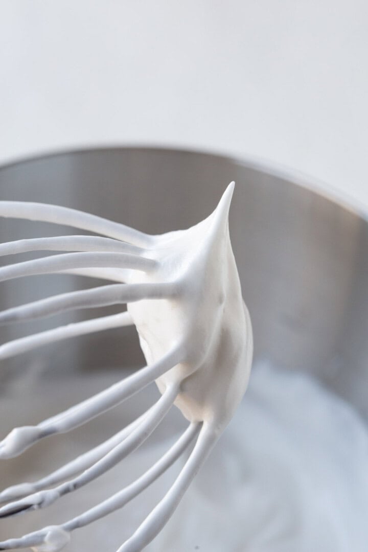 whipped meringue on a beater with a stiff peak.