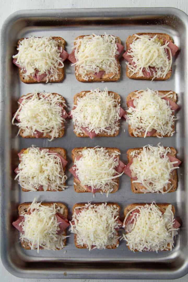 rye bread squares topped with thousand island dressing, slices of corned beef, sauerkraut, and swiss cheese.
